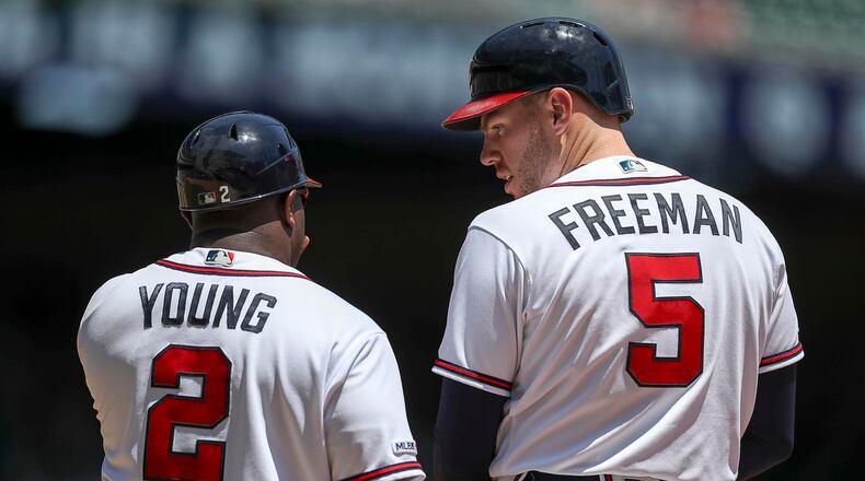 Braves first base coach Eric Young (left) talks with Freddie Freeman during a 2019 game. (ALYSSA POINTER/ALYSSA.POINTER@AJC.COM)