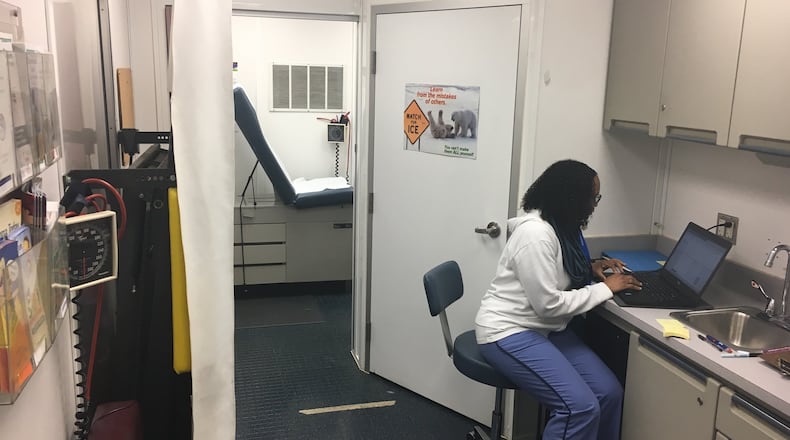 Nurse practitioner Tiffany Brown works on her computer Wednesday, Jan. 25, after completing a student visit in Dayton Public Schools’ mobile health unit outside River’s Edge Montessori School. JEREMY P. KELLEY / STAFF