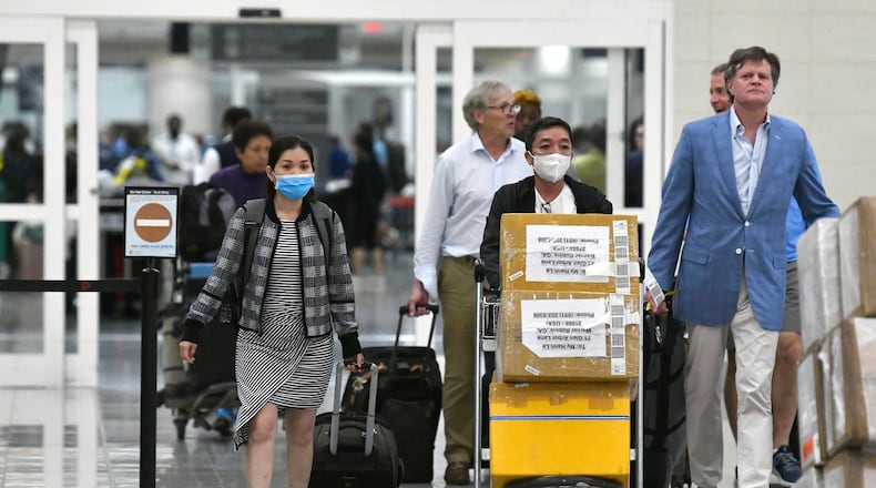 International travelers wearing masks arrive at Hartsfield-Jackson International Airport Tuesday, March 3, 2020. (Hyosub Shin / Hyosub.Shin@ajc.com)