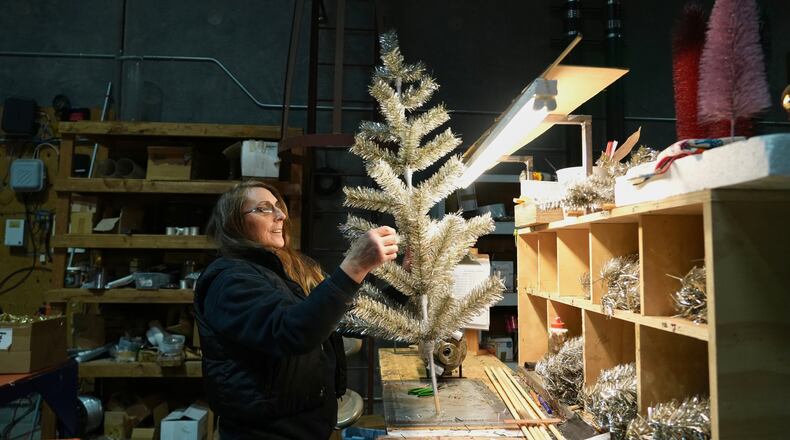 Melissa Webb assembles an artificial Christmas tree at Lee Display's warehouse, in Fairfield, Calif., Tuesday, Dec. 9, 2025. (AP Photo/Terry Chea)