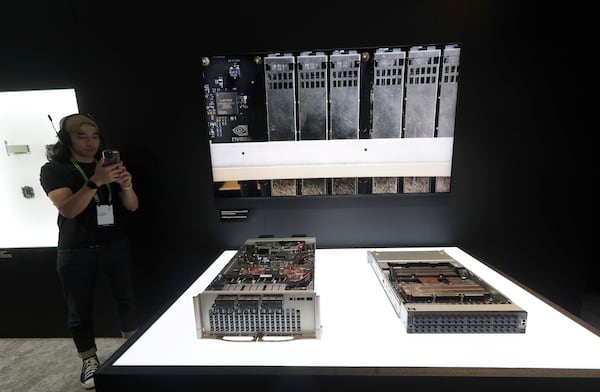 A member of staff takes a photo to Nvidia Quantum-X Photonics Q3450 CPO Switch System during the Computex 2025 exhibition in Taipei, Taiwan, Wednesday, May 21, 2025. (AP Photo/Chiang Ying-ying)