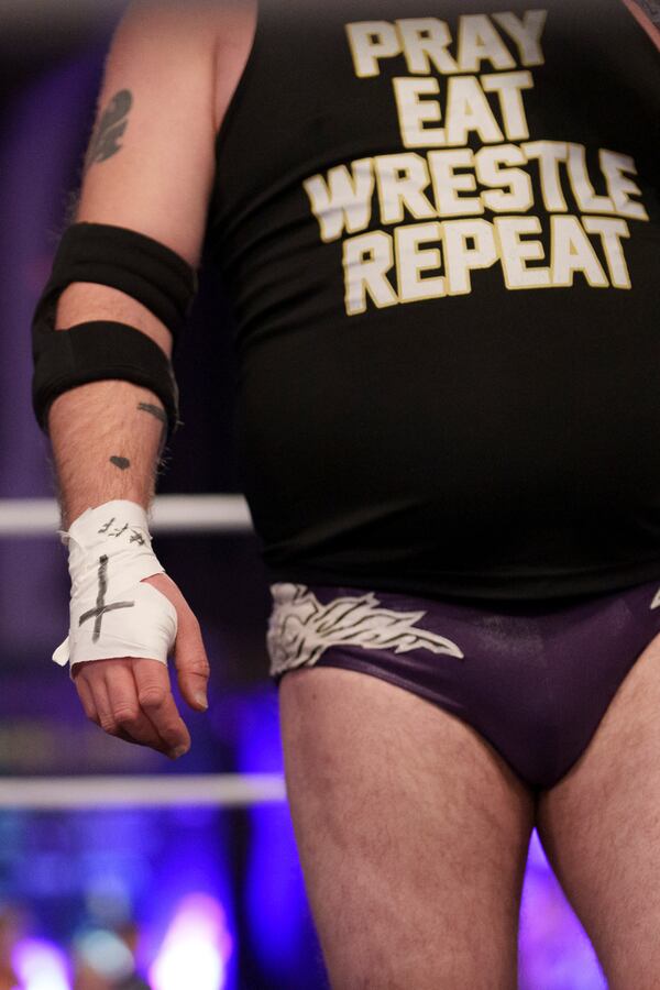A cross is seen on the hand of Gareth 'Angel' Thompson, founder of the Kingdom Wrestling charity during a wrestling bout at St Peter's Church in Shipley, Saturday, March 29, 2025. (AP Photo/Jon Super)