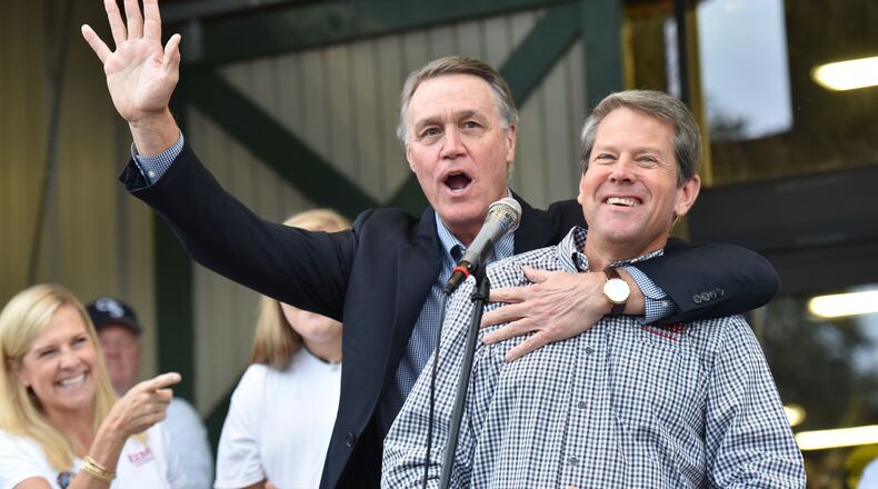 GOP gubernatorial candidate Brian Kemp (right) reacts as U.S. Senator David Perdue wishes him a happy birthday in Statesboro on Nov. 2, 2018. HYOSUB SHIN / HSHIN@AJC.COM
