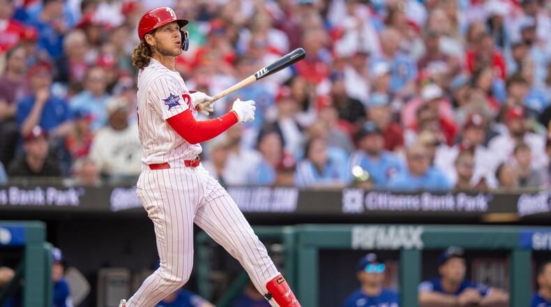 Philadelphia Phillies' Alec Bohm hits a three-run home rum during the fifth inning of an opening-day baseball game against the Texas Rangers, Thursday, March 26, 2026, in Philadelphia. (AP Photo/Chris Szagola)