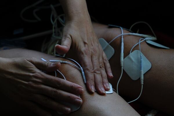 Priscilla Grim applies electrotherapy pads to her knees on April 18, 2025, at her apartment in New York. (AP Photo/Julia Demaree Nikhinson)