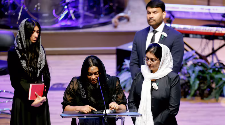 Jesni Sam speaks at her late husband's funeral on June 6, 2026, at Praise Community Church in Lawrenceville. She and Dave Fiji boarded a helicopter late May 29 after their Dawson County wedding, and the aircraft crashed not long after, killing Fiji. (Akili-Casundria Ramsess for the AJC)
