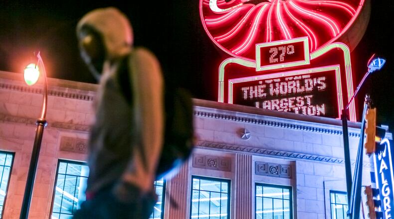 Derrick Harrison walks past the Coca-Cola temperature sign near Five Points in downtown Atlanta on the way to work on March 16, 2017.
