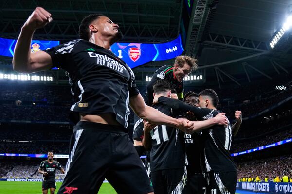 Arsenal players celebrate after Bukayo Saka, 2nd right, scored the opening goal during the Champions League quarterfinals second leg soccer match between Real Madrid and Arsenal at the Santiago Bernabeu stadium in Madrid, Wednesday, April 16, 2025. (AP Photo/Manu Fernandez)