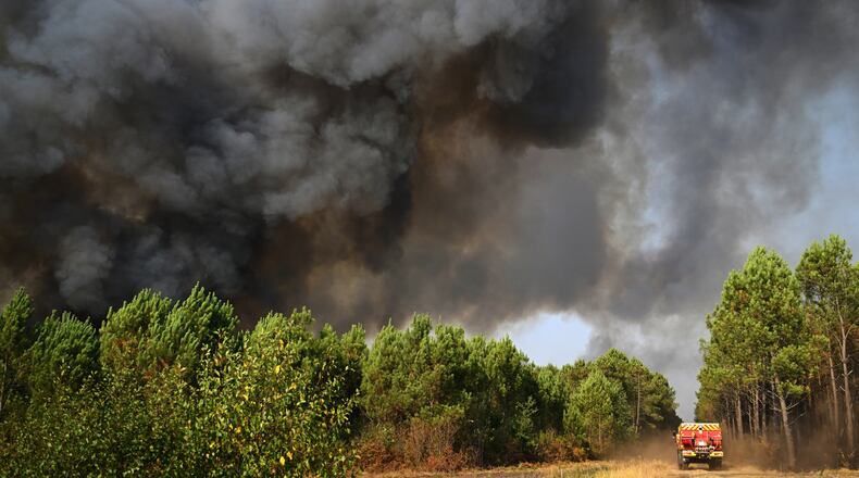 A smoke cloud rises as firefighters work to extinguish a fire in the forest near Blagon, during wildfires in southwestern France, Wednesday, July 29, 2026. (AP Photo/Emma Da Silva)