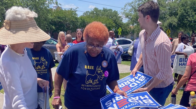 Supporters of President Joe Biden claim campaign promotion materials during the opening celebration for the "Black Voters for Biden-Harris" field office in Savannah. (Adam Van Brimmer/AJC.com)
