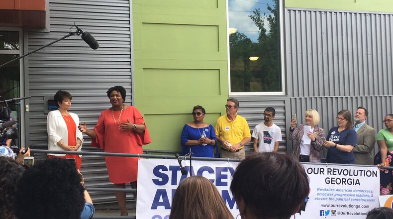 Democratic gubernatorial candidate Stacey Abrams, second from left, speaks at her campaign headquarters on May 19, 2018. She was accompanied by the leaders of several prominent progressive groups as well as former Obama adviser Valerie Jarrett, left. Tamar Hallerman/AJC