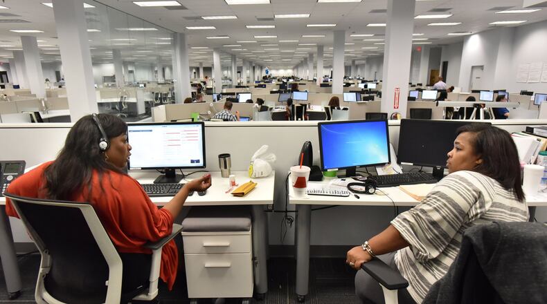 Roporscha Taylor (left) and Shanndria Hammon discuss a customer issue at the Chime Solutions in Morrow. The call center occupies a former J.C. Penney at Southlake Mall. HYOSUB SHIN / HSHIN@AJC.COM