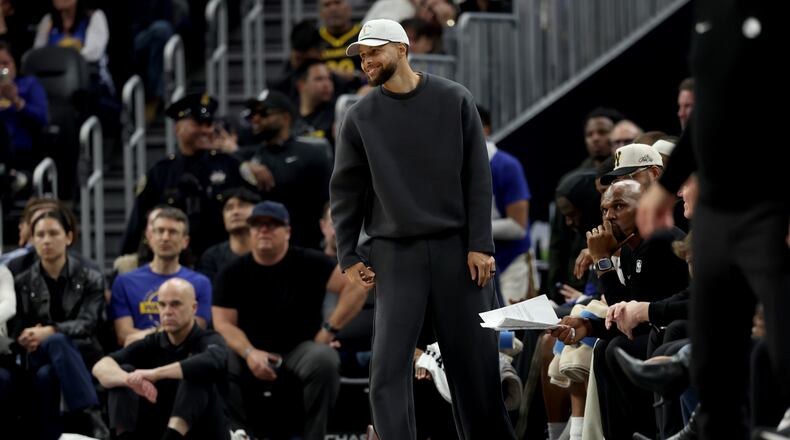 Golden State Warriors guard Stephen Curry stands at the bench during the first half of an NBA basketball game against the Memphis Grizzlies in San Francisco, Monday, Feb. 9, 2026. (AP Photo/Jed Jacobsohn)