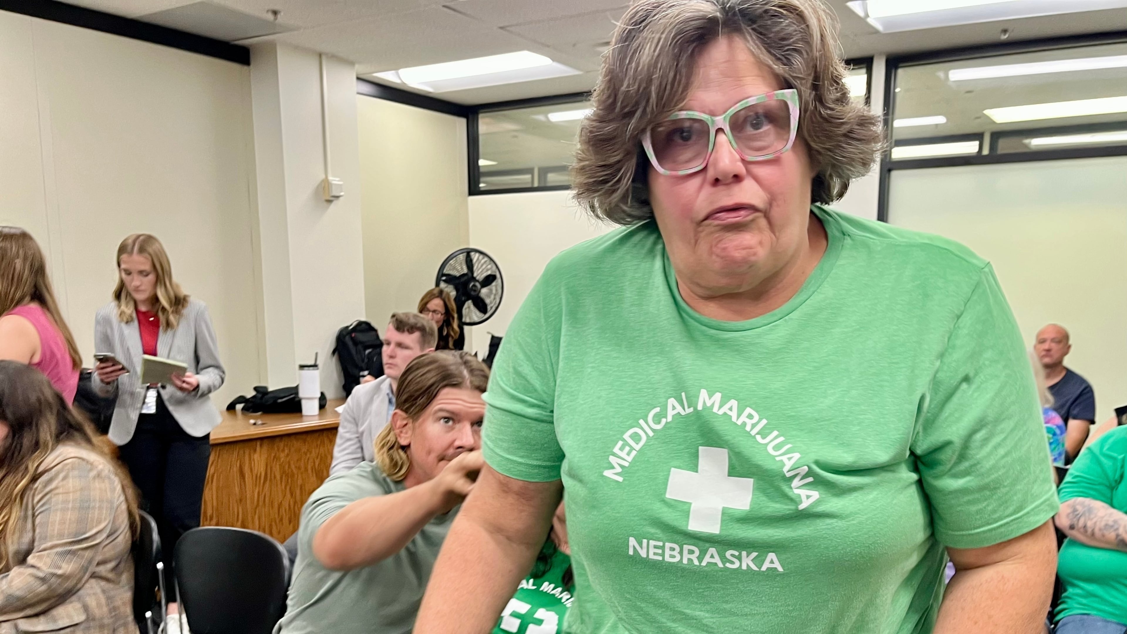 Lia Post, of Springfield, Neb., leaves a meeting of the Nebraska Medical Cannabis Commission, where she sobbed and begged its members to honor the will of the voters in approving comprehensive access to medical marijuana, Tuesday, Sept. 30, 2025 in Lincoln, Neb. (AP Photo/Margery Beck)