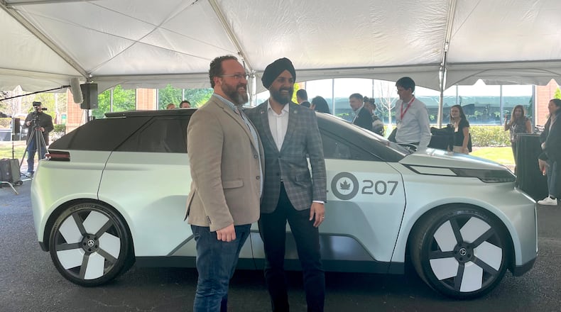 Canadian Automotive Parts Manufacturer’s Association President Flavio Volpe and Chief Technology Officer of APMA Colin Dhillon with Project Arrow, Canada's first zero-emissions concept vehicle. (Photo by Karen Huppertz for the AJC)