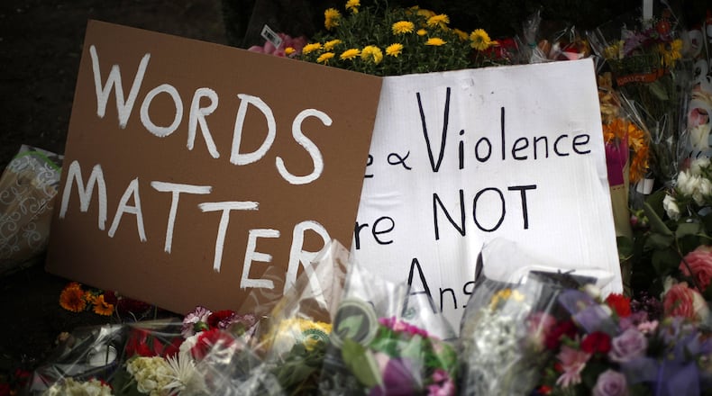 Flowers surround signs on Wednesday, Oct. 31, 2018, part of a makeshift memorial outside the Tree of Life Synagogue to the 11 people killed during worship services Saturday Oct. 27, 2018 in Pittsburgh. (AP Photo/Gene J. Puskar)