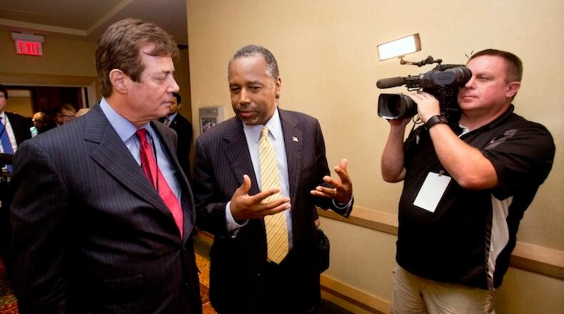 Donald Trump strategist Paul J. Manafort, left, chats with former presidential candidate Ben Carson as they head to a Trump for president reception at the Republican National Committee Spring Meeting, Thursday, April 21, 2016, in Hollywood, Fla. (AP Photo/Wilfredo Lee)