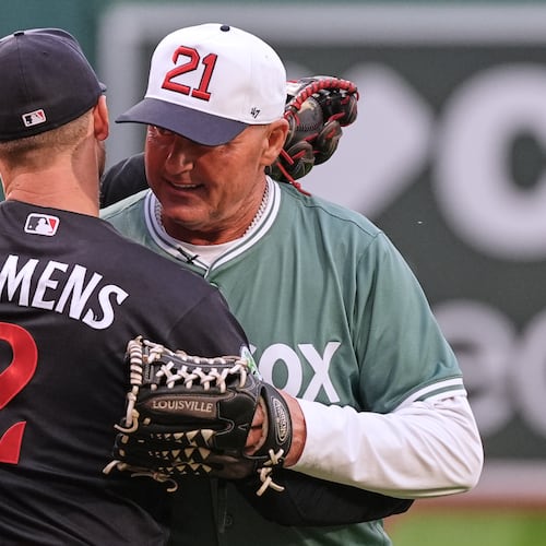 Former Boston Red Sox pitcher Roger Clemens, right, embraces his son, left, Minnesota Twins' Kody Clemens (2), after throwing out a ceremonial first pitch prior to a baseball game between the teams Friday, May 22, 2026, in Boston. (AP Photo/Charles Krupa)