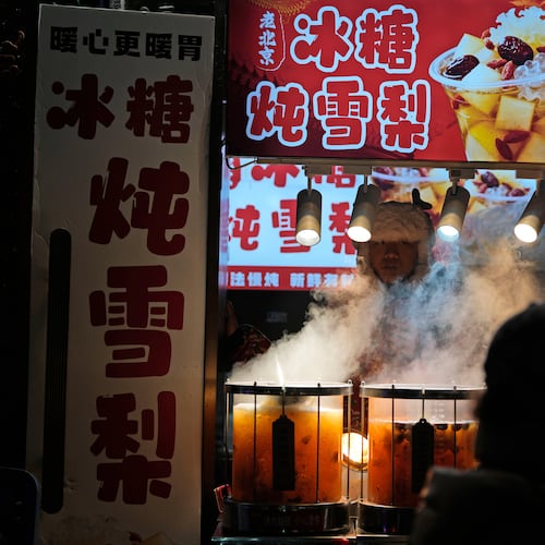 A vendor sells hot drinks in Beijing, Thursday, Dec. 18, 2025. (AP Photo/Ng Han Guan)