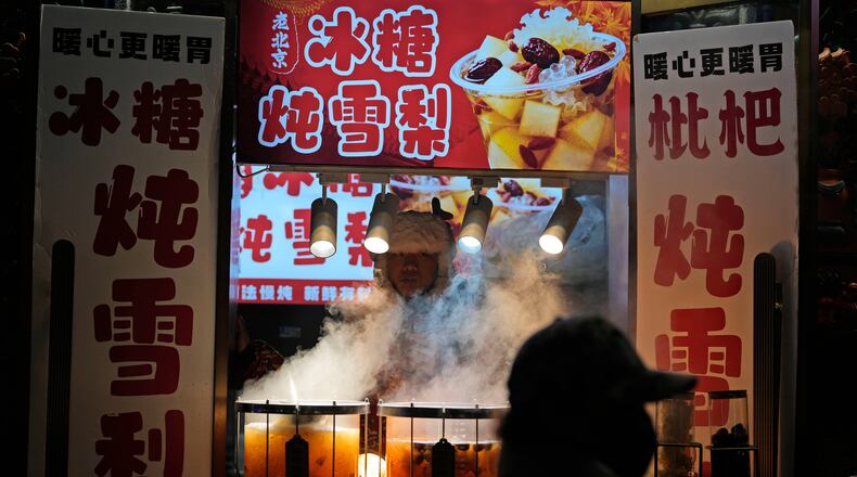 A vendor sells hot drinks in Beijing, Thursday, Dec. 18, 2025. (AP Photo/Ng Han Guan)