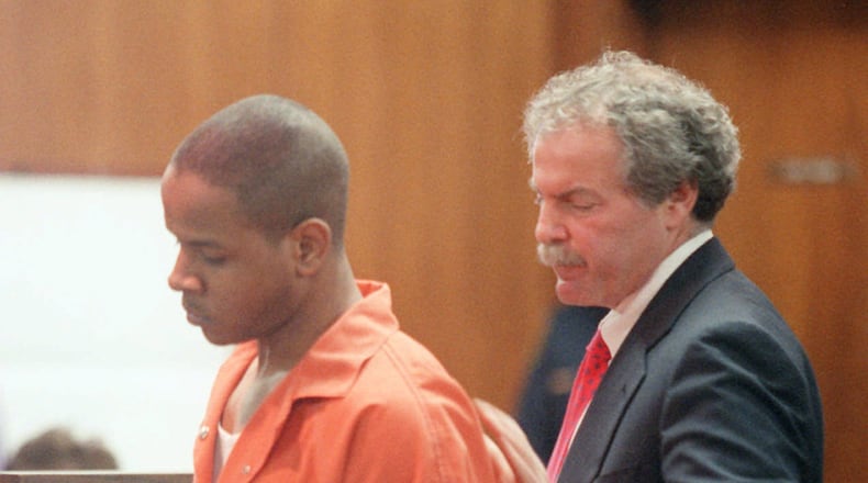 Sam Parham, left, takes his seat after Judge Hilton Fuller sentences him in 1996 to three consecutive life sentences for his role in a gang slaying. His attorney, Mike Maloof tries to console him after the sentencing. (AJC photo/Philip McCollum)