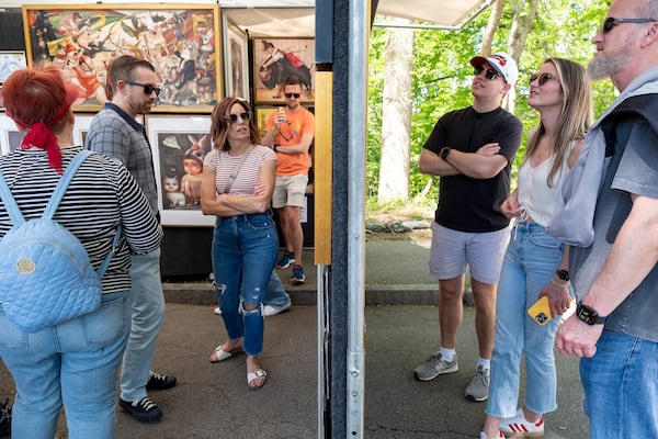 People view the work of Phoenix artist Tanya Doskova at her booth during the Dogwood Festival in Piedmont Park. (Ben Gray for the AJC 2024)