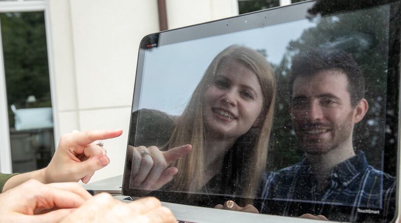 Graduate students Sarah Finch and James Finch are outside of Emory University's Mathematics and Science Center on Thursday, Sept. 16, 2021 and look over code on James laptop. The couple with their professor Jinho Choi participated and won Amazon competitions but have taken their chat bot project further than the Amazon parameters and they continue to push technology boundaries while studying at Emory University. (Jenni Girtman for The Atlanta Journal-Constition)
