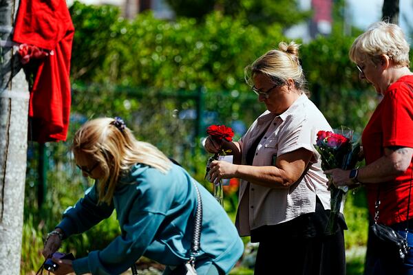 People lay flowers as tributes in memory of Liverpool player Diogo Jota, at Anfield Stadium, home of Liverpool, Thursday July 3, 2025. (Peter Byrne/PA via AP)