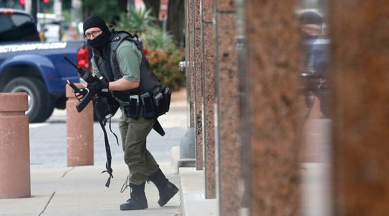 An armed shooter stands near the Earle Cabell Federal Building Monday, June 17, 2019, in downtown Dallas. The shooter was hit and injured in an exchange of gunfire with federal officers outside the courthouse.  (Tom Fox/The Dallas Morning News)