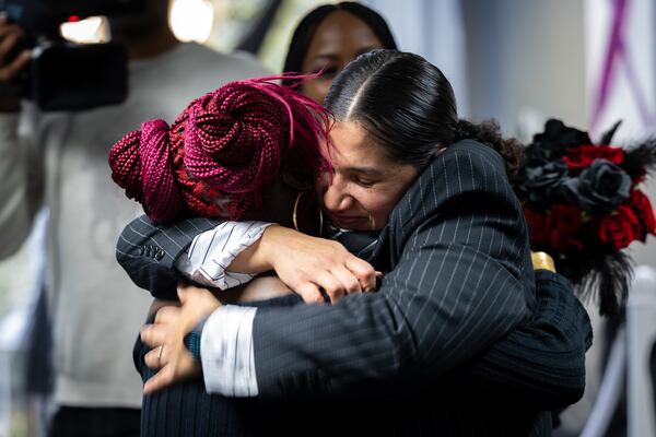 Isabel Ramirez (right) embraces her stepdaughter Tayana Powell after Ramirez is married to Tiara Powell. (Arvin Temkar/AJC)