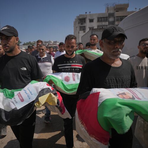 Mourners carry the flag-draped bodies of Palestinians killed in Israeli strikes during the war with Hamas, whose remains were recently recovered from the rubble, in Gaza City, Thursday, Aug. 20, 2026. (AP Photo/Jehad Alshrafi)