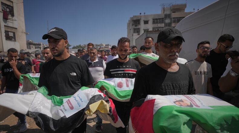 Mourners carry the flag-draped bodies of Palestinians killed in Israeli strikes during the war with Hamas, whose remains were recently recovered from the rubble, in Gaza City, Thursday, Aug. 20, 2026. (AP Photo/Jehad Alshrafi)