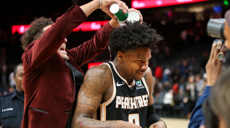 Atlanta Hawks guard Trae Young, left, pours water on guard Brandon Goodwin (0) after a 102-95 victory. (AP Photo/Brett Davis)
