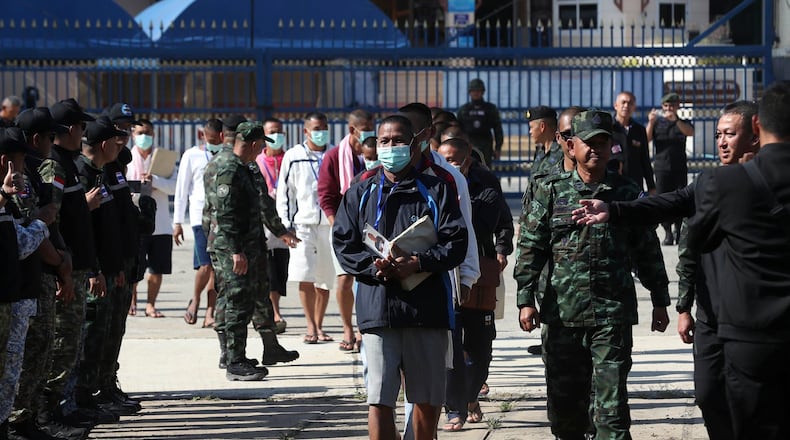 In this photo released by Agence Kampuchea Press (AKP), Cambodian soldiers, center, arrive after being captured and held by the Thai army, at Prum border gate, in Pailin province, Cambodia, Wednesday, Dec. 31, 2025. (AKP via AP)
