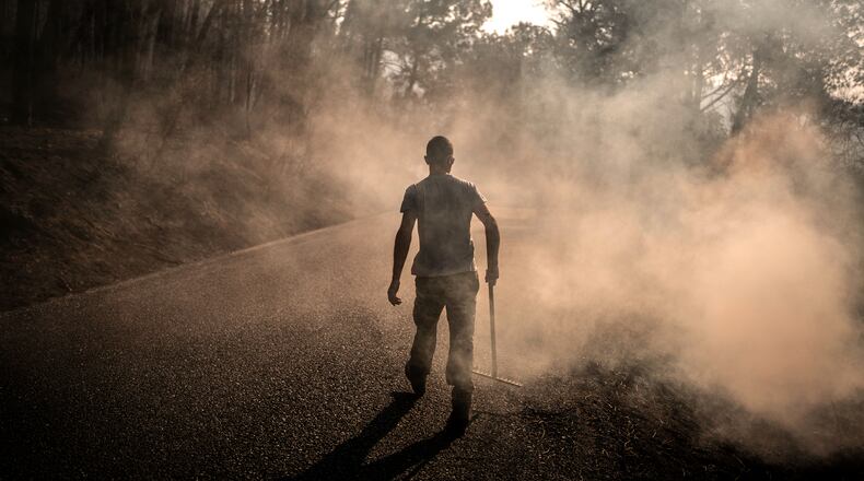 A man works to extinguish hot spots in an area burned by a wildfire near Casavieja, Ávila province, Spain, Wednesday, July 29, 2026. (AP Photo/Olmo Calvo)