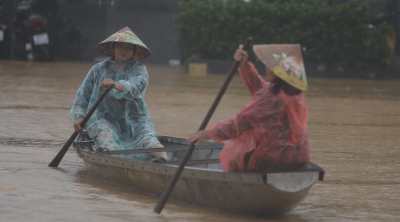 People paddle a boat on a flooded street in Hue, Vietnam, Tuesday, Oct. 28, 2025. (Van Dung/VNA via AP)