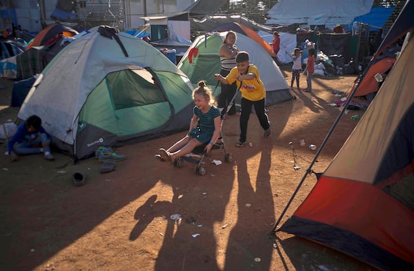 FILE - Children play at the Benito Juarez Sports Center that's serving as a temporary shelter in Tijuana, Mexico, Nov. 26, 2018, afternoon the mayor of Tijuana declared a humanitarian crisis in his border city and says that he has asked the United Nations for aid to deal with thousands of Central American migrants who have arrived in the city. (AP Photo/Ramon Espinosa, File)