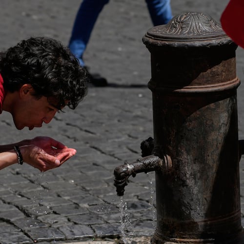 A man drinks water at a fountain in downtown Rome as temperatures are expected to reach 32 degrees Celsius (89.6 Fahrenheit), Tuesday, May 26, 2026. (AP Photo/Gregorio Borgia)