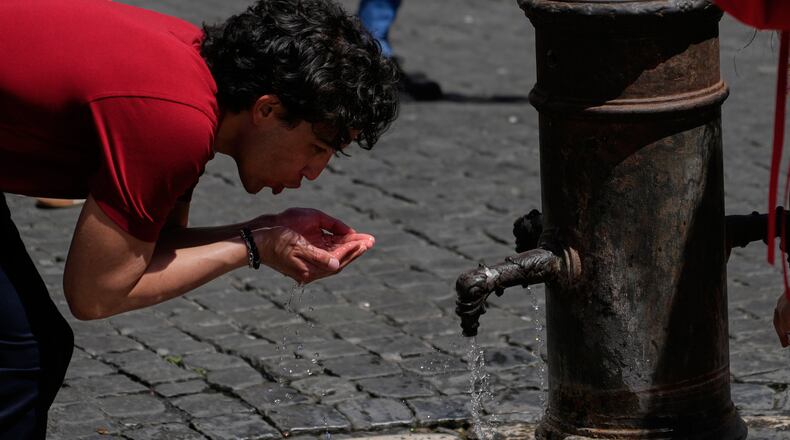 A man drinks water at a fountain in downtown Rome as temperatures are expected to reach 32 degrees Celsius (89.6 Fahrenheit), Tuesday, May 26, 2026. (AP Photo/Gregorio Borgia)