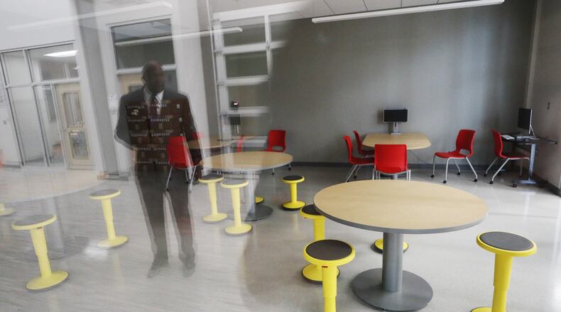 Principal Ronald Mitchell is reflected in the glass walls around one of the reading rooms in the new Ronald E. McNair Middle School in Decatur. BOB ANDRES / ROBERT.ANDRES@AJC.COM