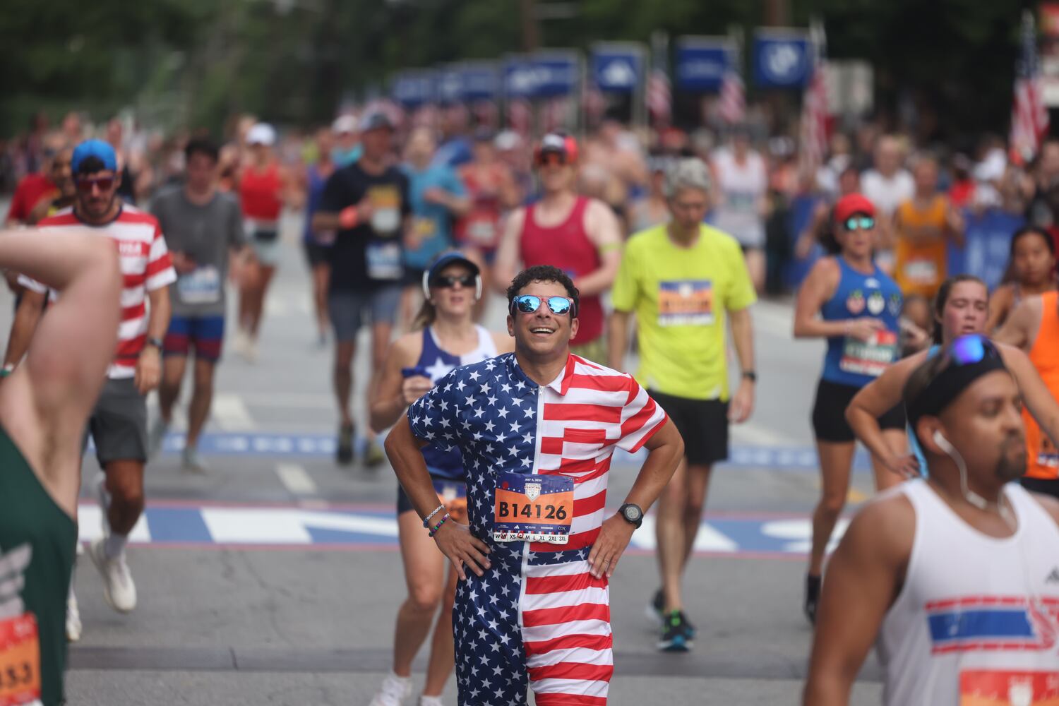 Runners celebrate at the finish of the 55th running of the Atlanta Journal-Constitution Peachtree Road Race in Atlanta on Thursday, July 4, 2024.   (Jason Getz / AJC)