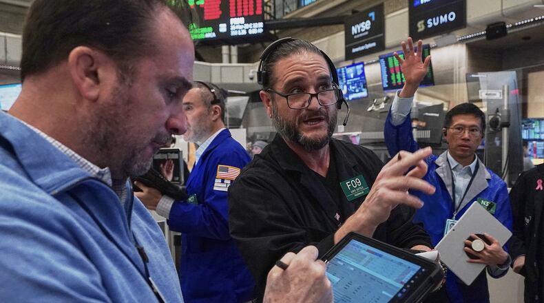 Chris Dattolo, center, works with fellow options traders on the floor of the New York Stock Exchange, Thursday, Jan. 22, 2026. (AP Photo/Richard Drew)