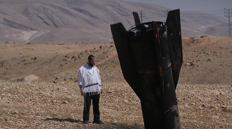 A man look at the wreckage of an Iranian missile that landed near the West Bank city of Jericho Monday, June 8, 2026. (AP Photo/Mahmoud Illean)