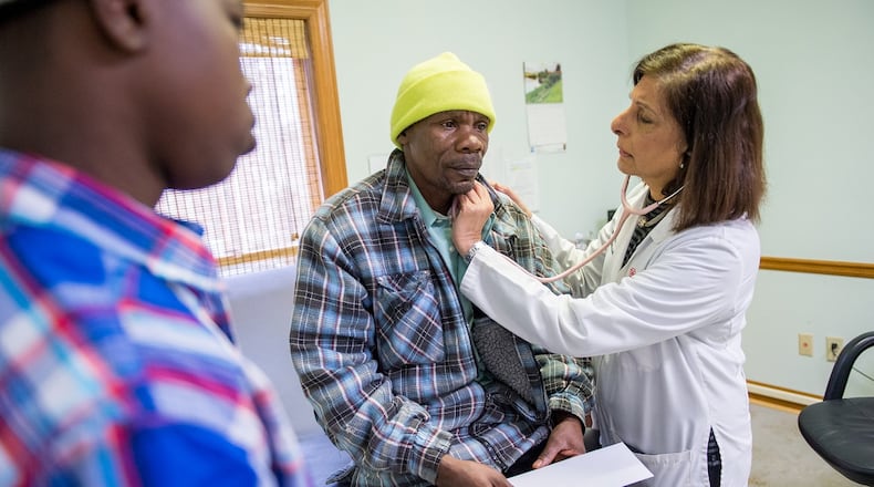 Dr. Gulshan Harjee, right, examines Simeon Gahungu, who is from Burundi and who came to the U.S. as a refugee form Tanzania, at the Clarkston Community Health Center on Dec. 17, 2017. Harjee co-founded the clinic to serve refugees, immigrants and other uninsured people. At left is Gahungu's son Matias Manirakiza, 17. BITA HONARVAR/SPECIAL