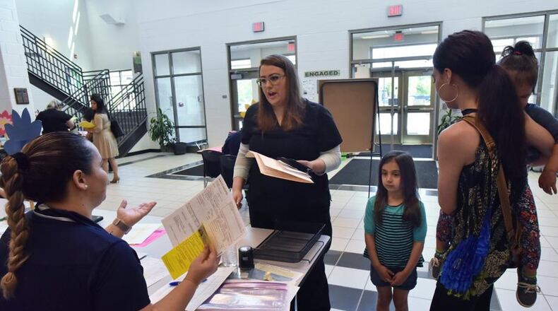 Parents took advantage of Gwinnett County's on-site kindergarten registration last year at Baggett Elementary School in Lawrenceville. The county devised a system to make the first day smoother by asking parents to fill out questionnaires about their kids beforehand and allowed rising kindergartners to visit the school in advance . HYOSUB SHIN / HSHIN@AJC.COM