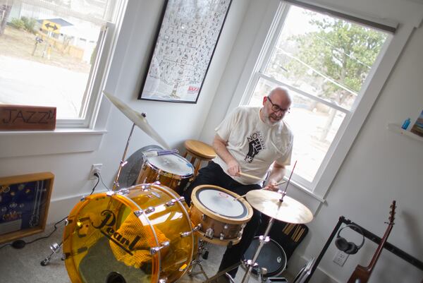 Paul Shaw, who was a jazz drummer in the United States Air Force Band, stays on the beat at home. Paul teaches guitar and cajon (a  Peruvian percussion instrument) at Decatur’s Frank Hamilton School of music and gigs with groups such as Evan Stepp & the Piners. (Courtesy of Dustin Timbrook)