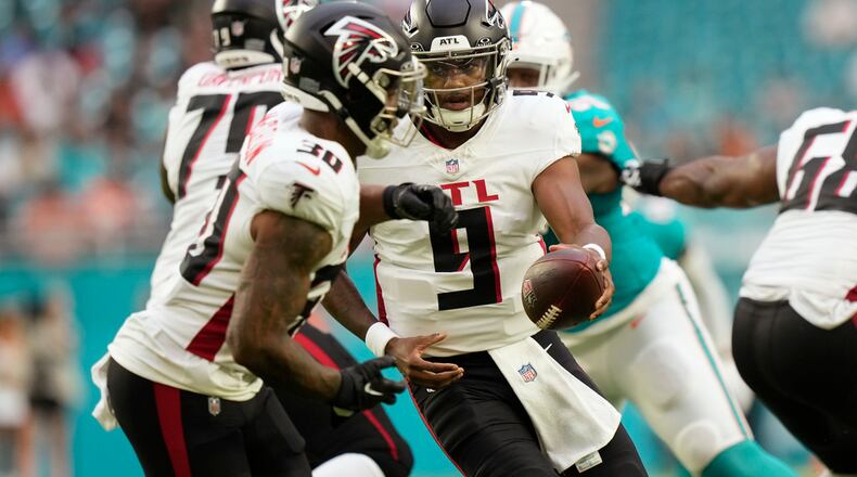 Atlanta Falcons quarterback Michael Penix Jr. (9) hands the ball to running back Jase McClellan (30) during the first half of a pre season NFL football game against the Miami Dolphins, Friday, Aug. 9, 2024, in Miami Gardens, Fla. (AP Photo/Wilfredo Lee)