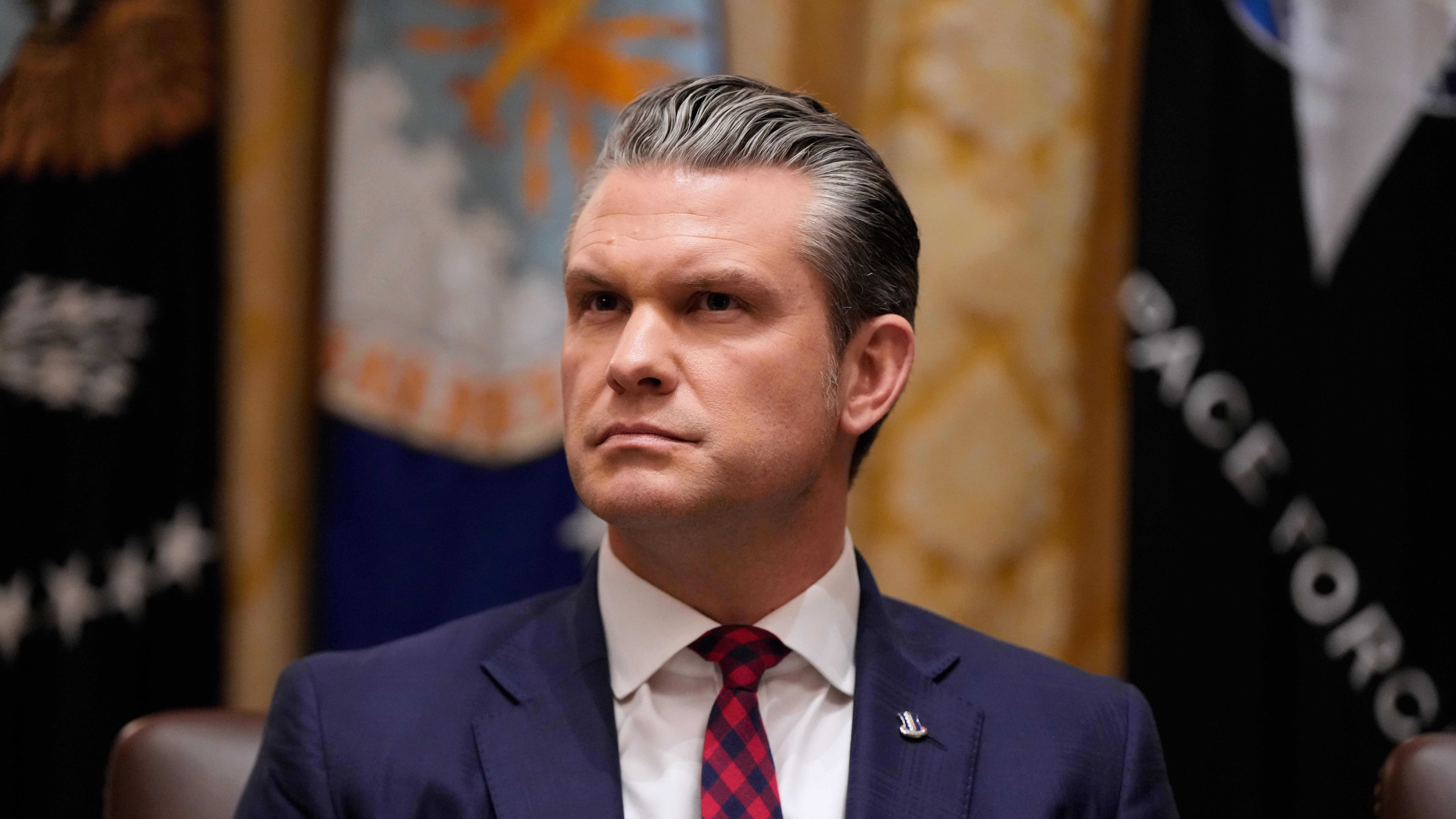Defense Secretary Pete Hegseth listens as President Donald Trump speaks during a Cabinet meeting at the White House, Tuesday, Dec. 2, 2025, in Washington. (AP Photo/Julia Demaree Nikhinson)