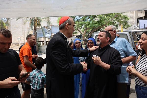 Latin Patriarch Cardinal Pierbattista Pizzaballa, center, speaks with a worshipper as part of a religious delegation to the Gaza Strip led by two patriarchs from Jerusalem visiting the Holy Family Catholic Church struck by an Israeli shell the day before in Deir al-Balah, Friday, July 18, 2025. (Latin Patriarchate of Jerusalem via AP)