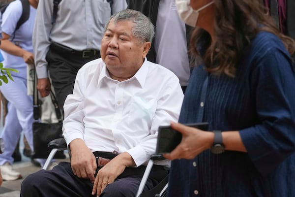 Premchai Karnasuta, the president of Italian-Thai Development Co arrives on a wheelchair at Bang Sue Police Station in Bangkok, Thailand, Friday, May 16, 2025 to surrender to police on criminal negligence charges for the collapse of a Bangkok high-rise during a March 28 earthquake. (AP Photo/Sakchai Lalit)